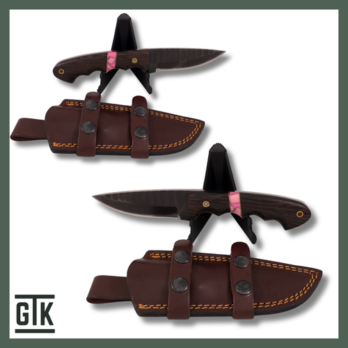 Isle Royale Sunset full-tang fixed-blade knife with dark wood handle, bright pink resin and metal inlays, hammered blade details, and brown sheath.